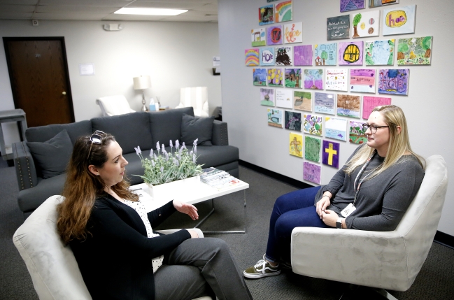 Two Palomar partner agency employees sit and talk at Palomar