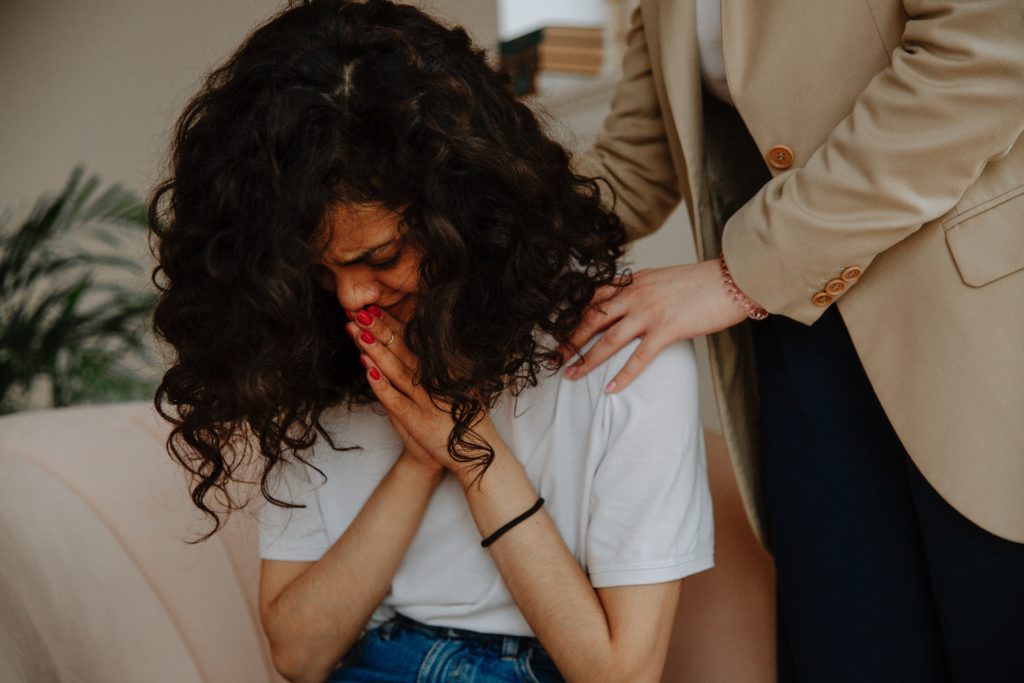 A woman is comforted by another person