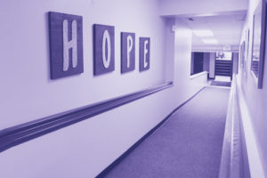 A photo of a hallway with a sign that says "HOPE" at Palomar